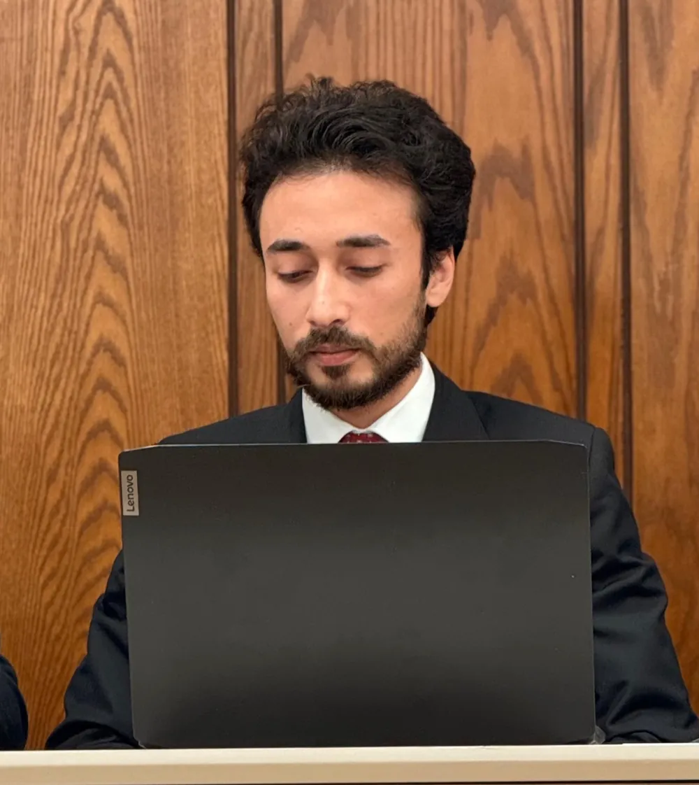 Ahmed working on a laptop at a panel table