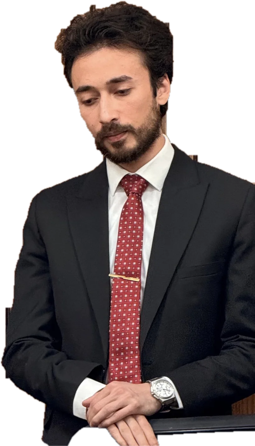 Ahmed Soliman in a dark suit and red tie